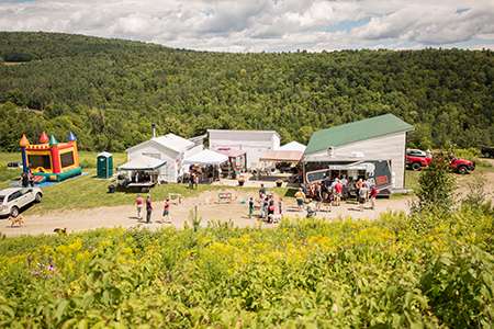A group of people outside some buildings on the grounds of Dog Mountain