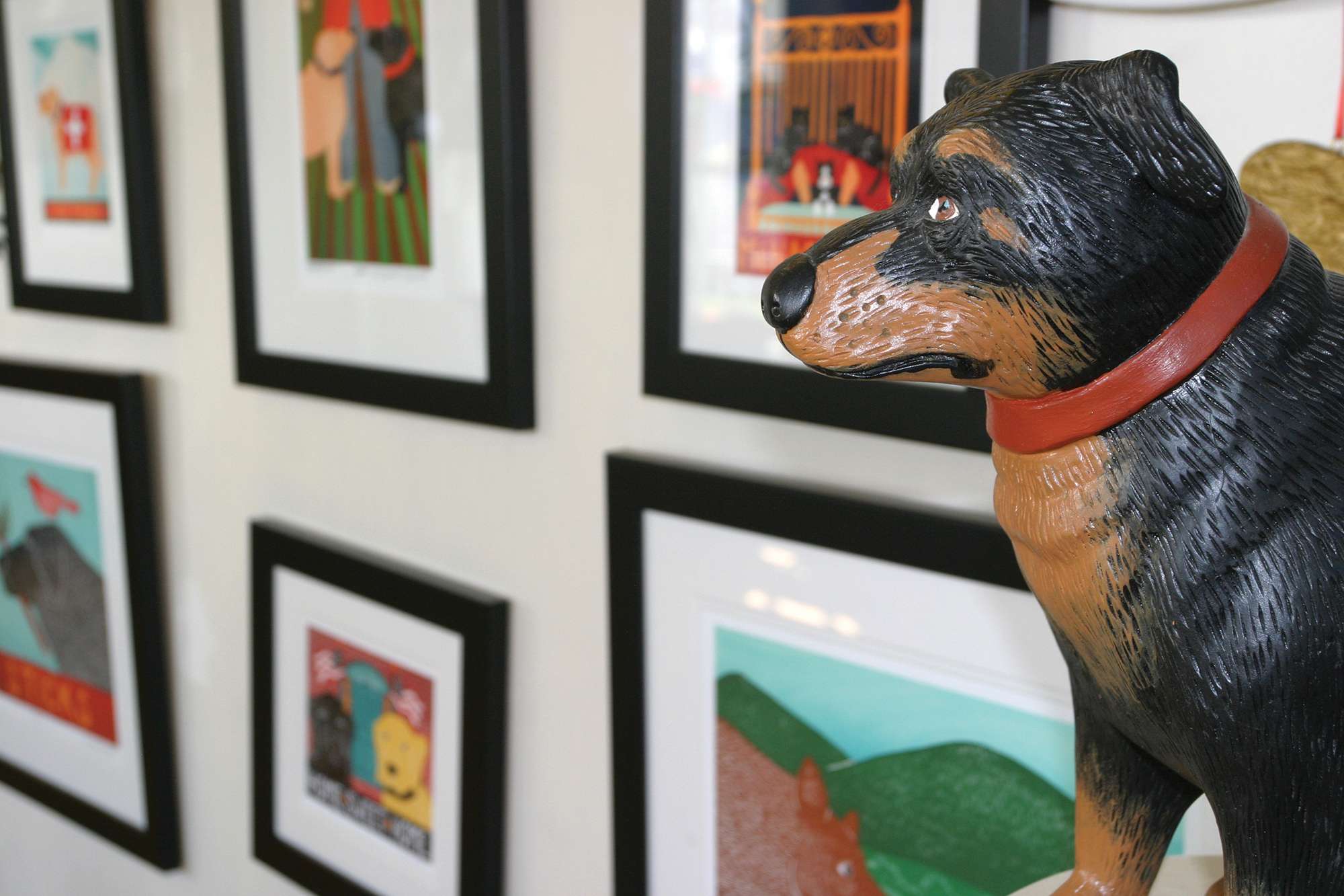 Close-up of Stephen Huneck dog statue and framed art on walls