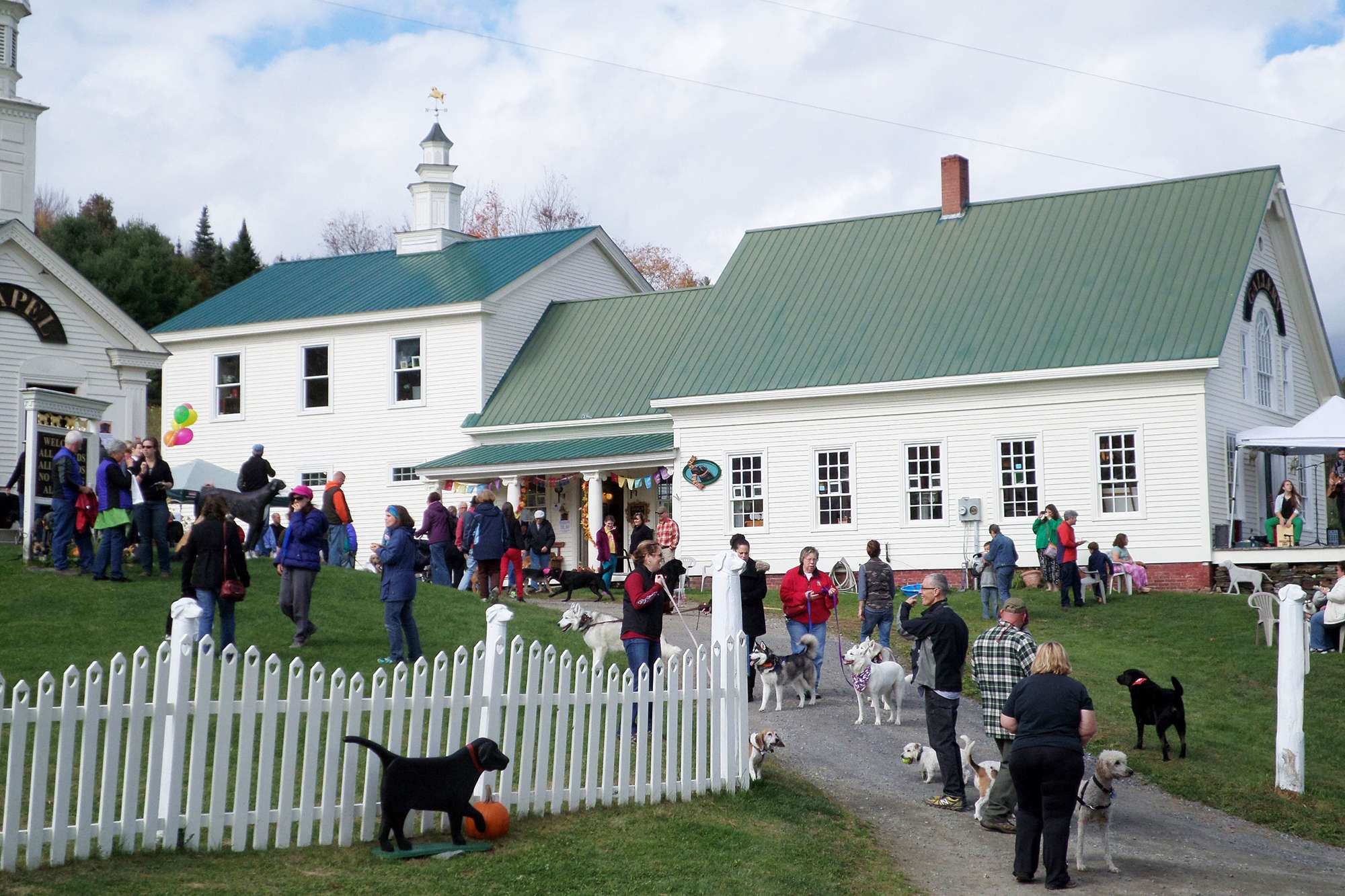 Fall Dog Party people and dogs in front of Stephen Huneck Gallery